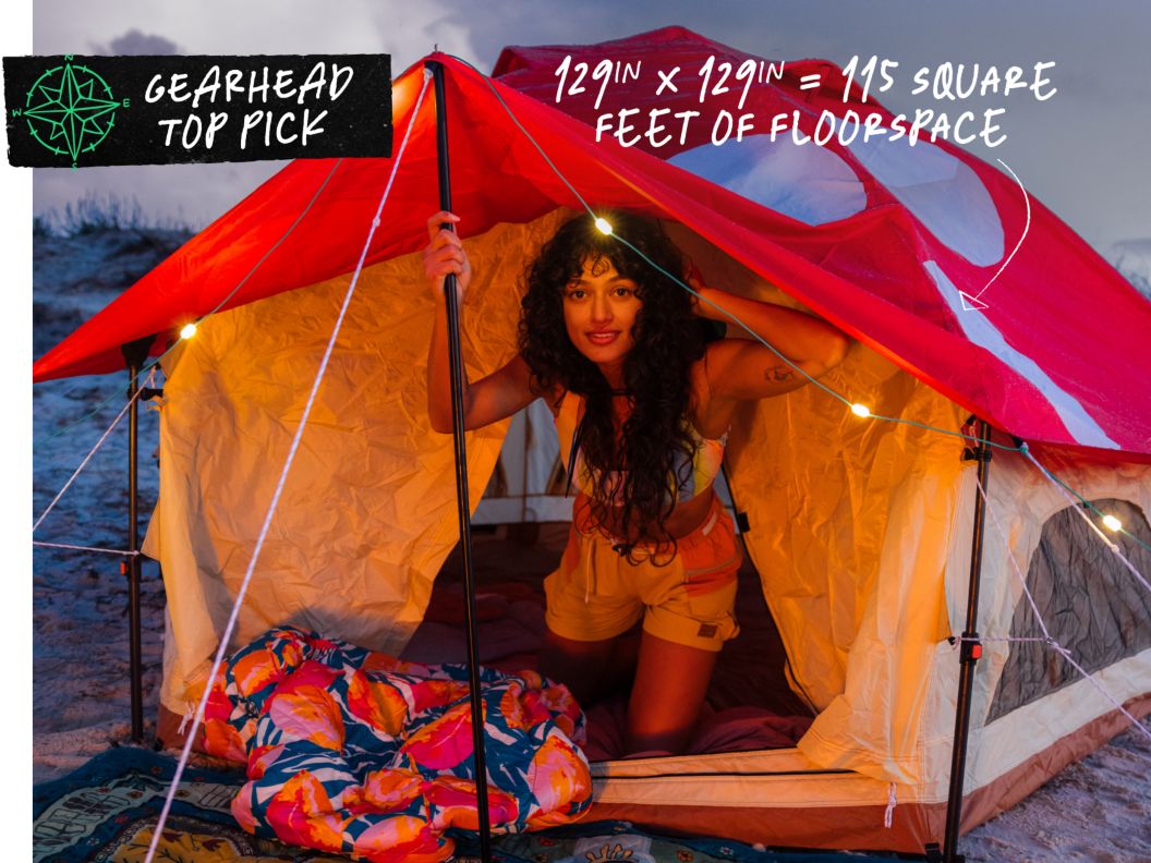 A woman emerges from a mushroom-printed tent. Text overlay reads: Gearhead top pick, 129in x 129in = 115 square feet of floorspace.